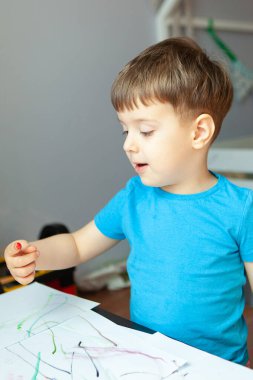 Yaratıcı çocuk, odasında resim yapıyor. Anaokulu çocukları için eğitici oyunlar