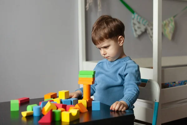 Yaratıcı çocuk renkli küplerle oynuyor. Küçük çocuk evde oynuyor. Anaokulu çocukları için eğitici oyunlar