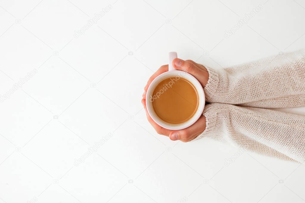 Female hands holding cups of coffee on white table background