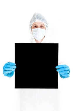 Koruyucu giysili, eldivenli ve maskeli bir adam elinde bir işaret tutuyor. Beyaz bir arkaplanda izole edilmiş