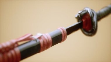Parlak arkaplanda süsleri olan Asyalı bir katana.