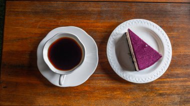 Sade kahve fincanı ve eski ahşap masa manzaralı kek. Boşluğu kopyala.