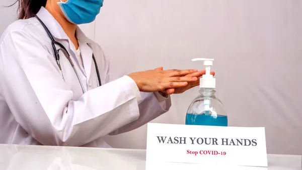Doktor, Coronavirus veya Covid-19 'dan korunmak için elini nasıl temizleyeceği, alkol-jel ve sprey kullanacağı gösterilir.