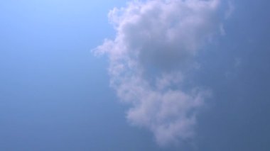 Kümülüs kabarık ve mavi arka planda parlak beyaz bulutlar. Yavaş yavaş hareket et.