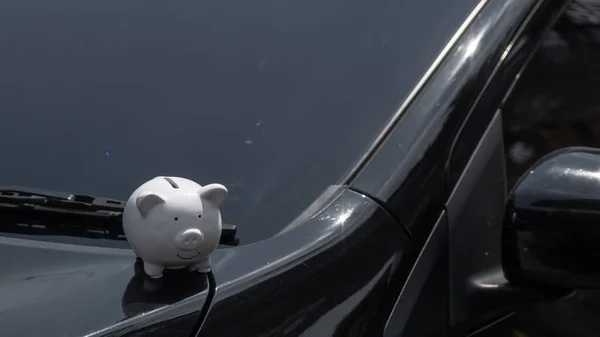 Piggy bank on a car, saving money for buy new car. Saving money and loans for car concept
