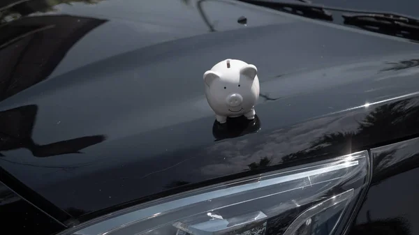 Piggy bank on a car, saving money for buy new car. Saving money and loans for car concept