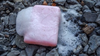 Ahşap üzerinde köpükler olan pembe sabun, virüsten elini temizliyor. şifa kavramı,