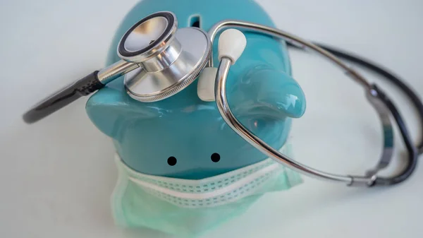 Stetoskop ve Domuz Kumbarası Koruyucu Tıbbi Yüz Maskesi takıyor, beyaz arka planda izole edilmiş..