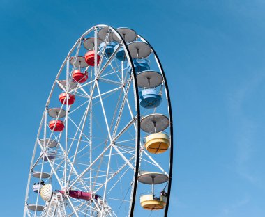 Arka planda mavi gökyüzü olan bir dönme dolap.