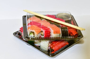 Sushi rolls pack in plastic container on white background. clipart