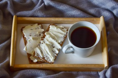 Sade kahve, tereyağlı ekmekli ekmek tepsisi ve rahat bir ekose..