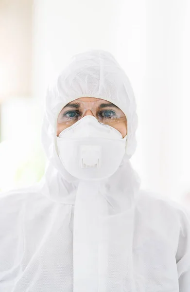 Portrait of protected woman with safety suit, glasses and mask before a pandemic or virus