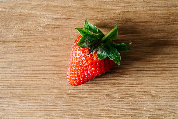 Eine Erdbeere Auf Einem Hölzernen Hintergrund — Stockfoto