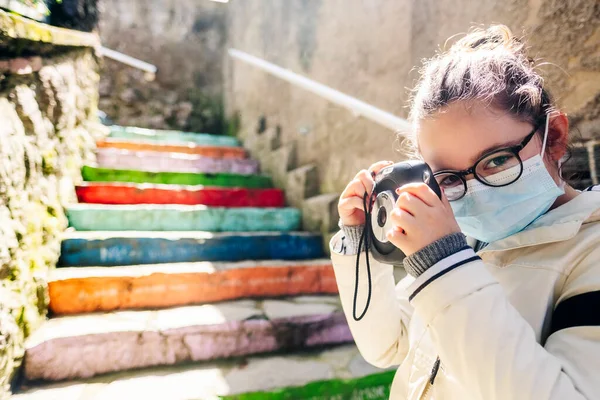 Maskeli bir kız fotoğraf makinesiyle gezmeye çıkar.