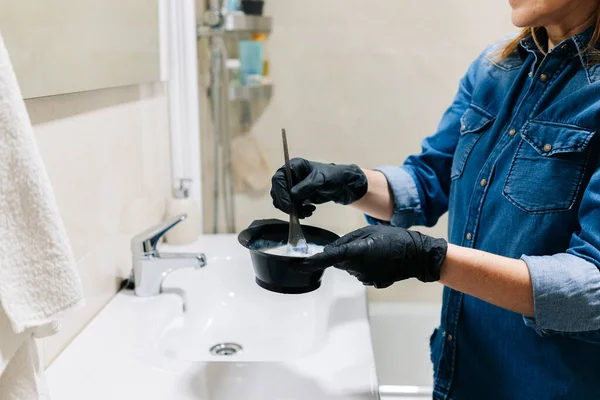 Bir kadın saçını evde boyar..