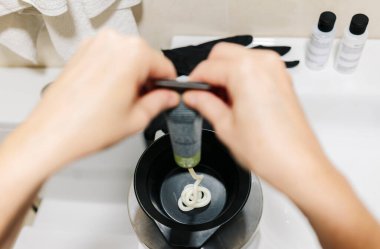 Bir kadın saçını evde boyar..