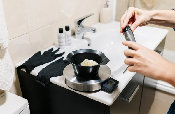 Una mujer se tiñe el pelo en casa . — Foto de Stock