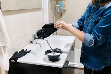 Bir kadın saçını evde boyar..