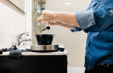 Bir kadın saçını evde boyar..