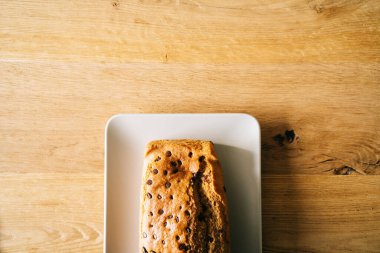 Tahta arka planda çikolata parçalı sünger keki.