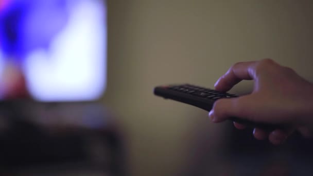 Main avec une télécommande de télévision changeant le canal — Video