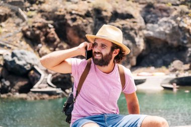 El Hierro, Kanarya Adaları 'ndaki bir sahil kasabasında bir turist cep telefonu kullanıyor.