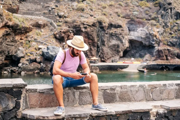 El Hierro, Kanarya Adaları 'ndaki bir sahil kasabasında bir turist cep telefonu kullanıyor.