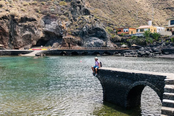 El Hierro, Kanarya Adaları 'nda bir sahil kasabasında şapka ve sırt çantalı bir turist.