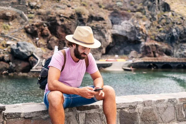 El Hierro, Kanarya Adaları 'ndaki bir sahil kasabasında bir turist cep telefonu kullanıyor.