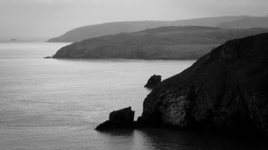 Birleşik Krallık 'ın güney kıyısında denize doğru yükselen burunların siyah ve beyaz görüntüsü.