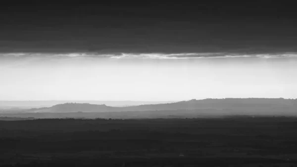 遠くの丘のテレフォトビューでは 霧に覆われた イギリスのマルヴァーン丘陵のモノクローム画像 — ストック写真