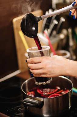 Kız sıcak sıcak şarabı bardaklara dolduruyor. Bardakların kenarları şekerle kaplıdır..