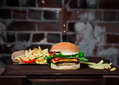 BRICK BACKground 'daki hamburgerin yanında patates kızartması. Stüdyo fotoğrafı