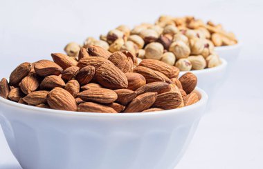 Bademlerin ön planında fındıklı beyaz tabaklar.