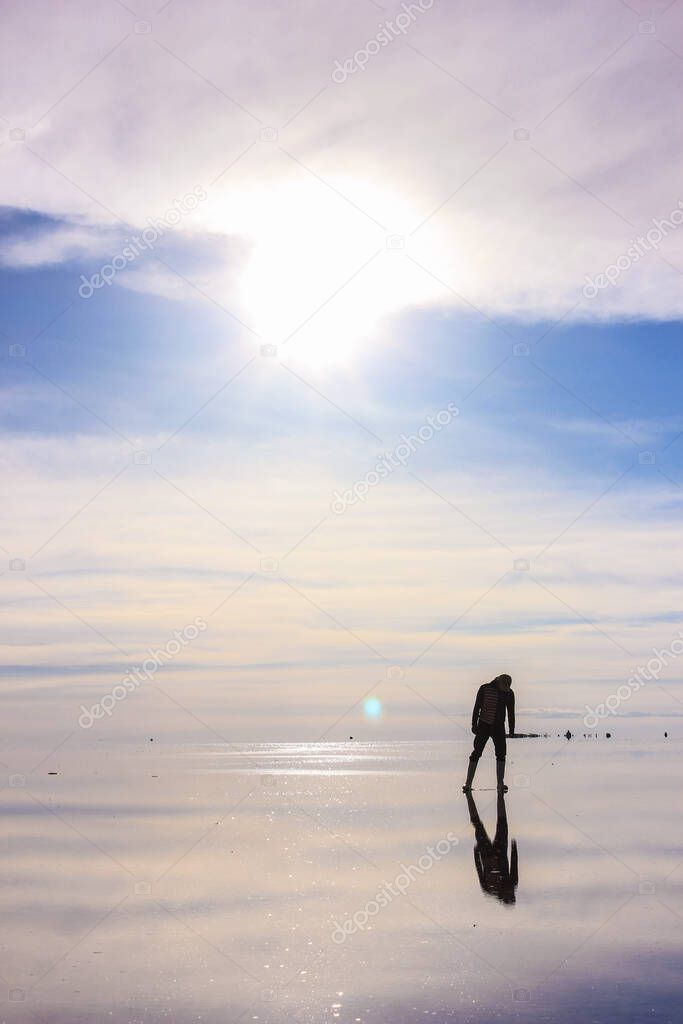 silhouette of person in a blue water mirror landscape