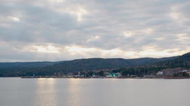 Deniz manzarası dağlardan günbatımına kadar bulutların arkasında.