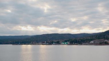 Deniz manzarası dağlardan günbatımına kadar bulutların arkasında.