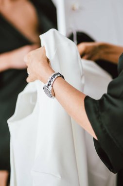 Kız elinde beyaz bir elbise, elinde saatler, kendini soyutlama.