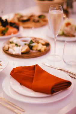 Masa takımı, kırmızı peçete beyaz bir tabakta yatıyor.