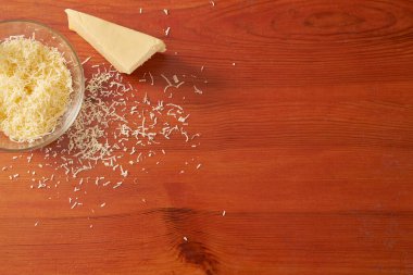 Pişirmeye başlamadan önce ahşap bir masada rendelenmiş peynir.