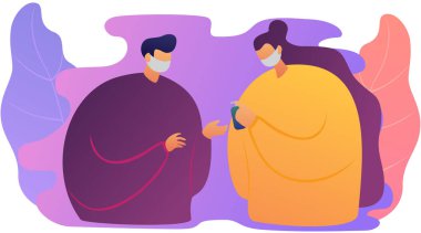 Maskeli kadın ve erkek ellerini temizleme spreyiyle yıkıyor.