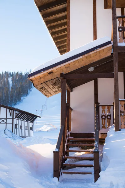 Porche de la maison basse sur fond de piste de ski — Photo