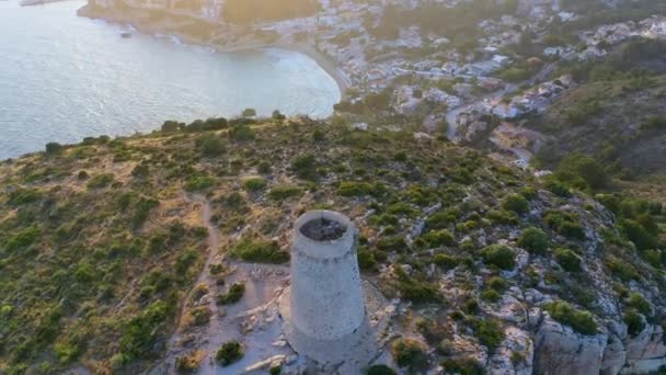 Vue aérienne d'une ancienne tour et d'une plage confortable au milieu de la ville sur fond de coucher de soleil et de montagnes incroyables 