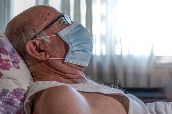 Face of old man with face mask, Spain, Europe.