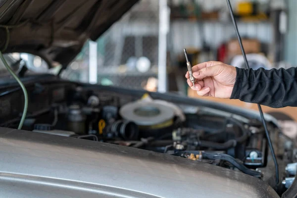 Professional mechanic man remove grow plug of the car, repair and maintenance garage