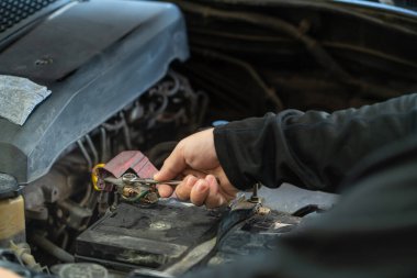 Tamirci, pil direğini, teftişi ve bakımını sıkmak için İngiliz anahtarı aletleri kullanıyor. 