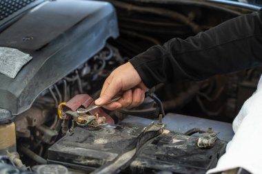 Tamirci, pil direğini, teftişi ve bakımını sıkmak için İngiliz anahtarı aletleri kullanıyor. 