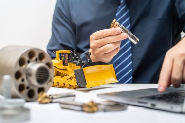 Profesyonel makine mühendisi, hidrolik piston pompasının piston ayakkabısını teftiş ediyor ve iş günü için rapor yazıyor, ağır makine konseptini tamir ediyor.