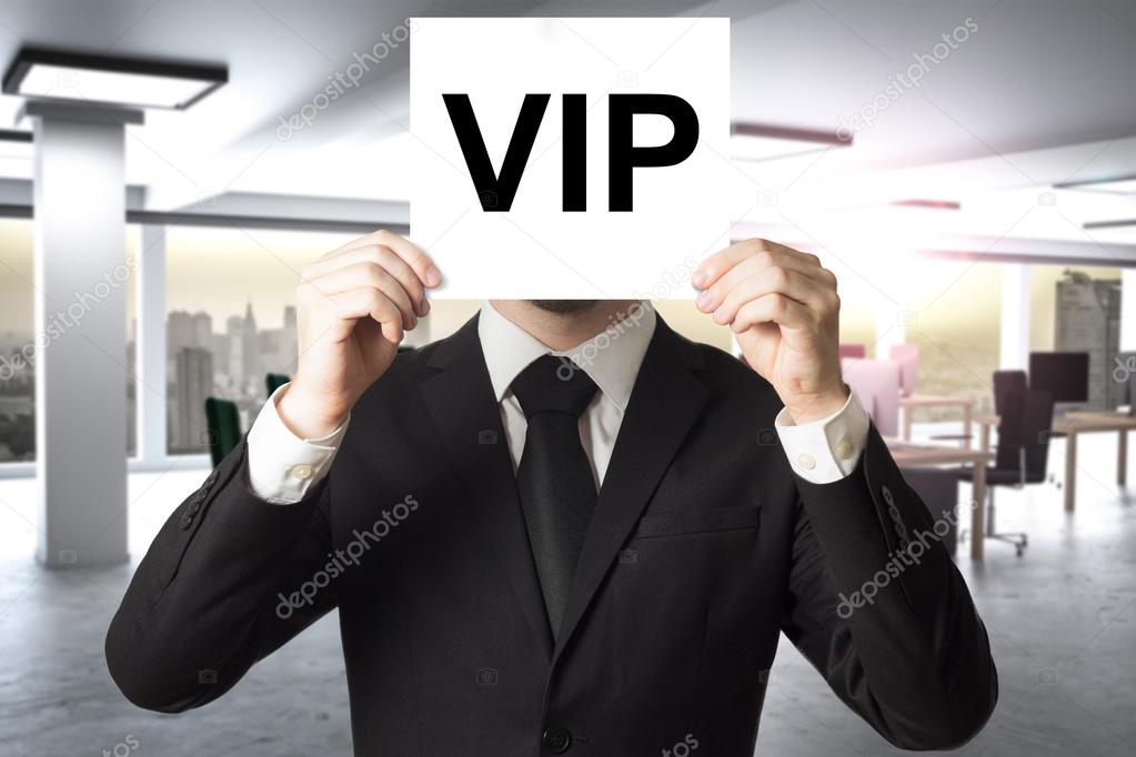 businessman hiding face behind sign vip