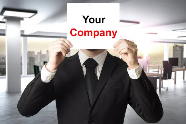 Uomo d'affari nascondendo faccia dietro segno la vostra azienda — Foto Stock